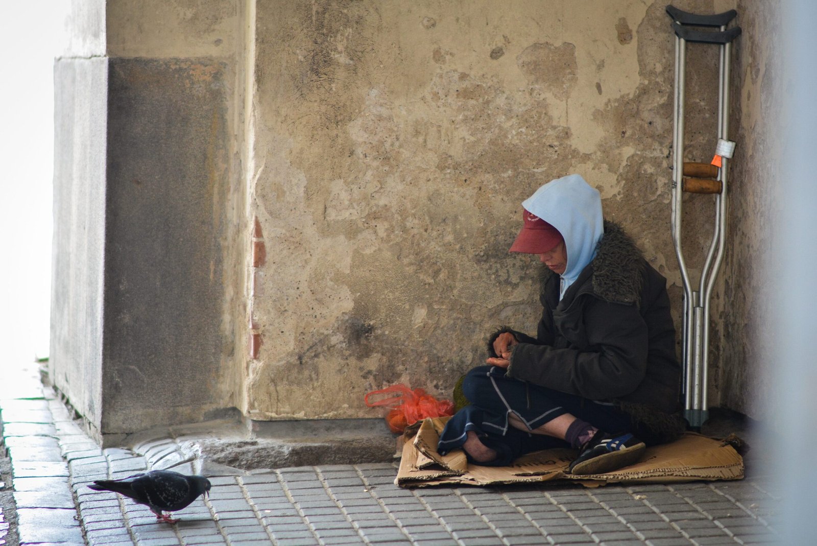 Žmogus sėdi gatvėje