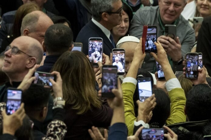 Popiežius Leonas XIV telefonų ekranuose / EPA nuotr.