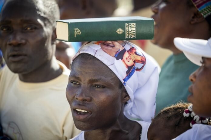 Moteris su Biblija Mušimos šventovėje / EPA nuotr.