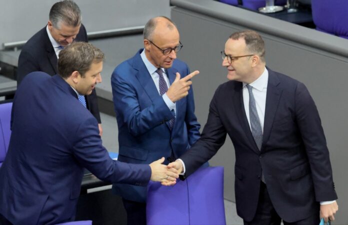 Iš kairės: Vokietijos finansų ministras Larsas Klingbeilas, Vokietijos kancleris Friedrichas Merzas ir Krikščionių demokratų sąjungos (CDU) Bundestago frakcijos pirmininkas Jensas Spahnas Vokietijos Bundestago posėdyje Berlyne / EPA nuotr.